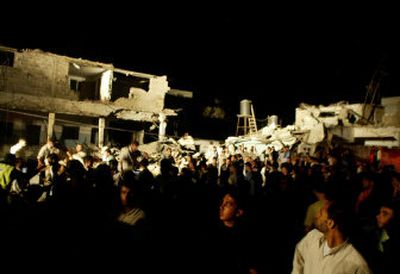 
Palestinians gather in front of buildings damaged in an explosion in Gaza City on Monday. An explosion destroyed a house after nightfall, killing four and injuring at least 30 others, residents and officials said. 
 (Associated Press / The Spokesman-Review)