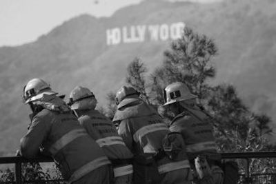 
Firefighters watch as a helicopter drops water Monday on a brush fire near the famed Hollywood sign near Griffith Observatory in Los Angeles. 
 (Associated Press / The Spokesman-Review)