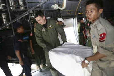 
A soldier from Myanmar and a U.S. airman work together to unload food packages at Yangon airport Monday.  Associated Press
 (Associated Press / The Spokesman-Review)