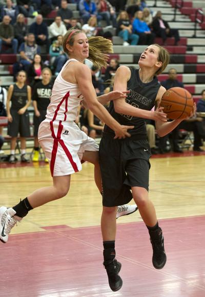 Mead's Delany Junkemier, right, draws the foul and makes the lay-in while Ferris' Brittney Johnson tries to defend Friday, Dec. 13, 2013 at Ferris High School. The Mead girls won easily 74-48 over the Saxon girls. (Jesse Tinsley / The Spokesman-Review)