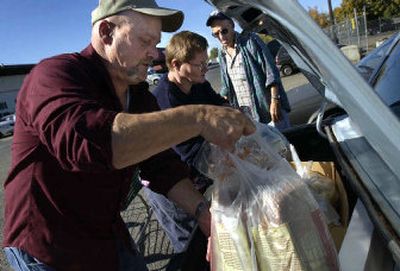 
Agency Relations Coordinator Tony Bellotti helps Alice and Don Richmond load food into their car at Second Harvest Food Bank on Tuesday morning. 
 (Holly Pickett / The Spokesman-Review)