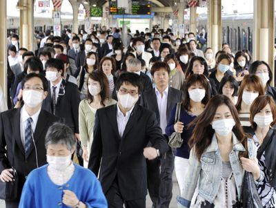 Commuters wear masks as precaution against swine flu at Sannomiya station in Kobe, Japan, on Tuesday.  (Associated Press / The Spokesman-Review)