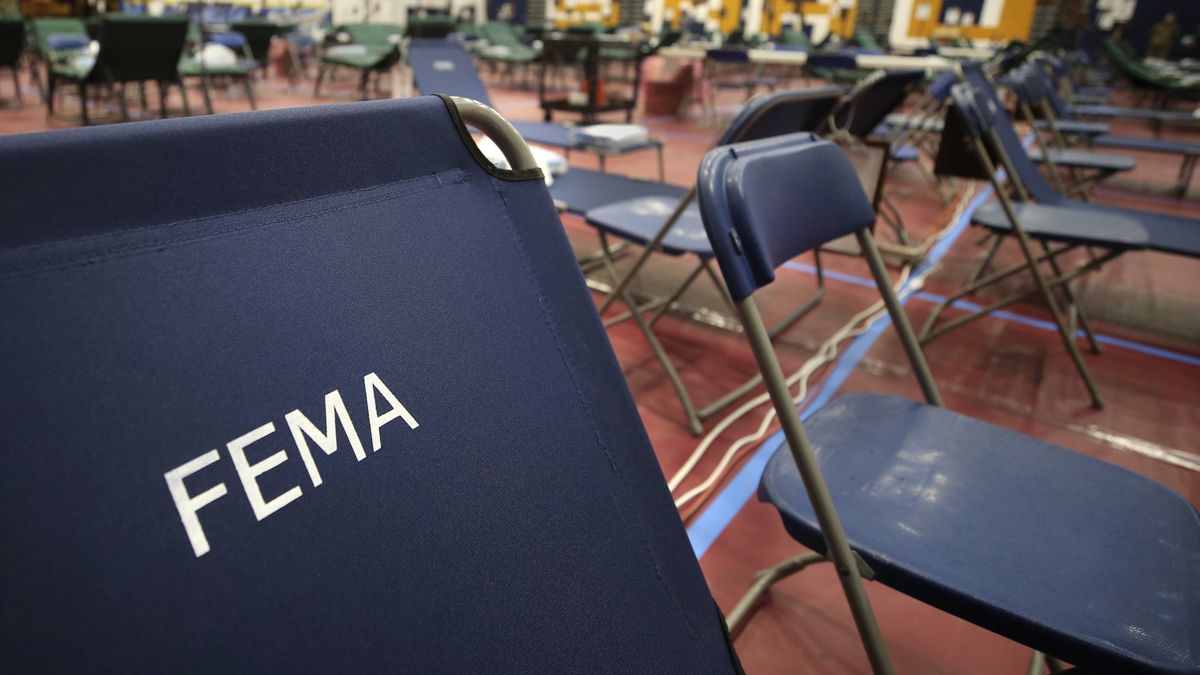 In this March 24, 2020 photo, a portable cot with the Federal Emergency Management Agency logo FEMA printed on the backrest, along with other cots, line the basketball court at a makeshift medical facility in a gymnasium at Southern New Hampshire University in Manchester, N.H. On Friday, Oct. 22, The Associated Press reported on stories circulating online incorrectly claiming FEMA workers aren’t subject to a vaccine mandate, and also falsely asserting that they’re being used to replace health care personnel who refuse to comply with such mandates.  (Charles Krupa)