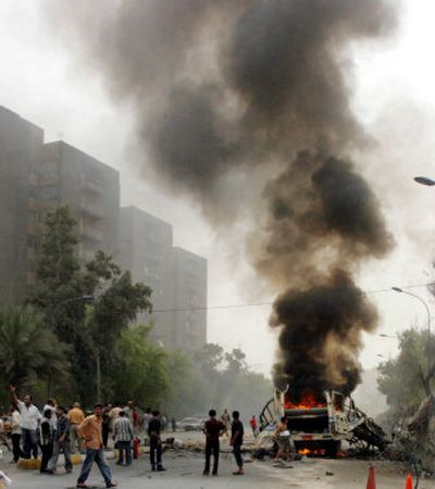 
Iraqis call for help after a bomb explosion in Baghdad on Sunday. 
 (Associated Press / The Spokesman-Review)