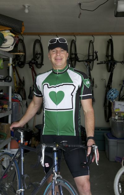 Chris Chapman poses in Portland wearing apparel whose central design feature is Chapman’s interpretation of the locally famous green heart-in-Oregon sticker created by Portlander Chris Bucci. (Associated Press)