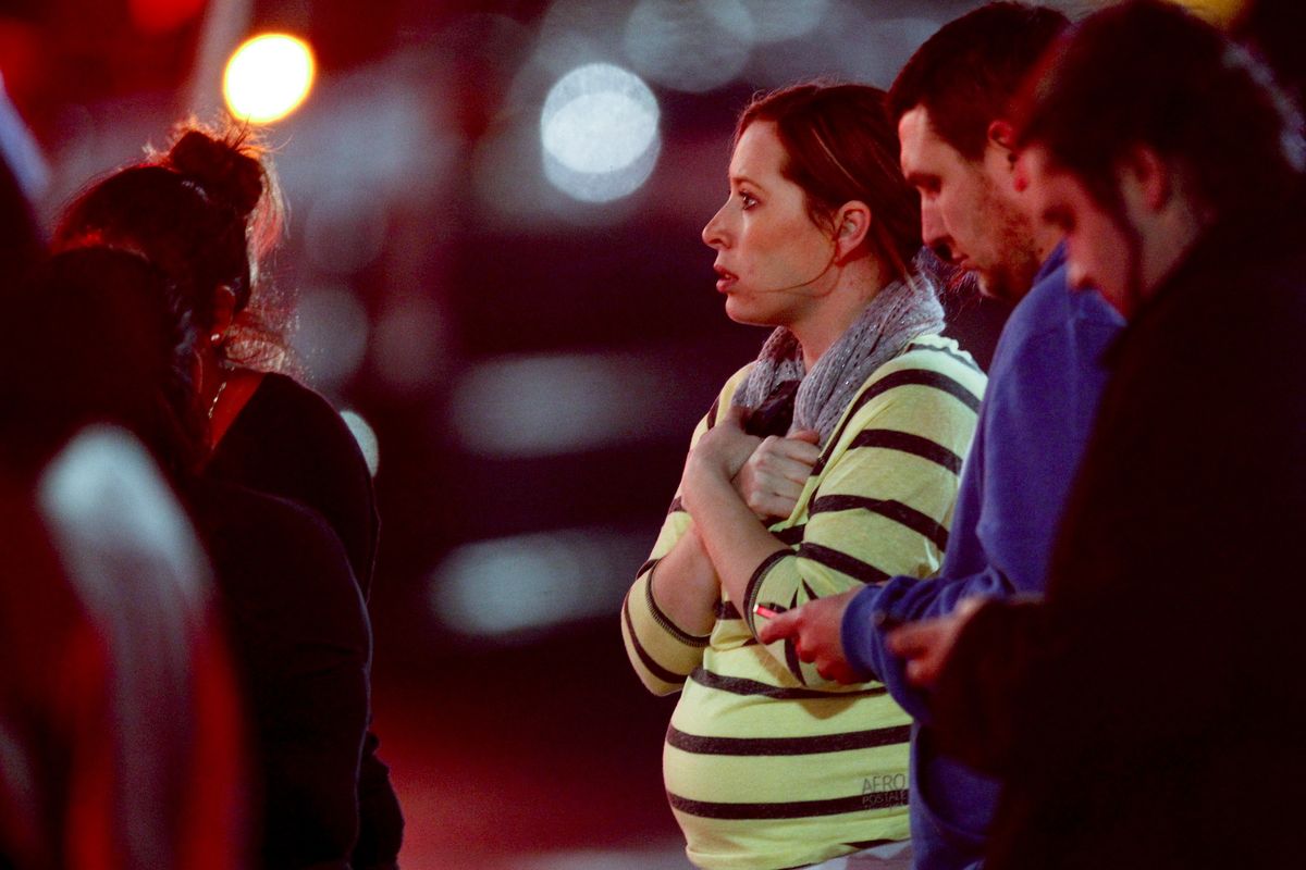 Onlookers observe the scene outside Clackamas Town Center, a Portland-area mall, where a gunman opened fire Tuesday. At least three people, including the shooter, are confirmed dead and at least one was wounded, sheriff’s deputies said. (Associated Press)