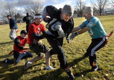 
Todd Hering tries to plow through the Zilar family defense – Chris Zilar, right, and his sons Zeb, left, and Jed – during the Chief Garry Turkey Bowl. 
 (Photos by Jed Conklin / The Spokesman-Review)