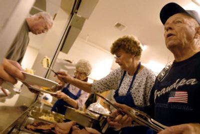
Bill Gaulin, right, and his wife, Evelyn, serve food at the free Thanksgiving dinner Saturday evening at the American Legion Post 143 in Post Falls. Gaulin said the veterans group does  its free dinner on the Saturday before Thanksgiving so it doesn't conflict with family commitments. 
 (Jesse Tinsley / The Spokesman-Review)