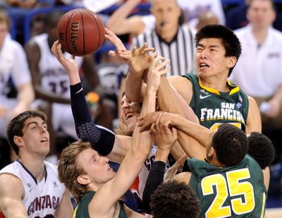 Gonzaga’s Kelly Olynyk, center, is certainly giving the effort as he mixes it up with San Francisco Dons in this battle for a rebound. (Tyler Tjomsland)