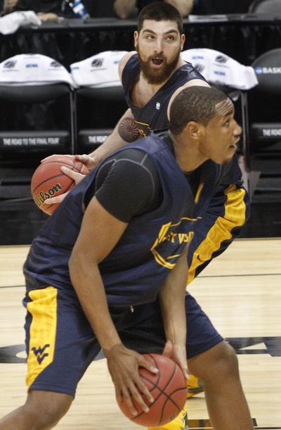 West Virginia’s formidable Kevin Jones, bottom, and Deniz Kilicli go through drills on Wednesday. (Associated Press)