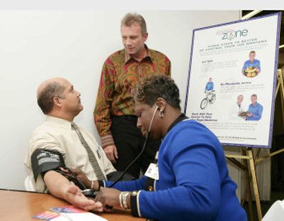 
Four-time Super Bowl champion Joe Montana, center, watches as Iris Taylor, Ph.D., president of Detroit Receiving Hospital, takes the blood pressure of Detroit Fire Commissioner Tyronne Scott, at the Detroit Medical Center. Montana is one of 65 million Americans with high blood pressure.
 (PRN / The Spokesman-Review)