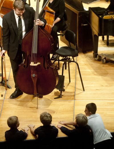 Hands-on learning: Patrick McNally, principal bass with the Spokane Symphony, lets his bass sustain a long, low note, as local students feel the vibrations through the floor on Wednesday at the Fox Theater in Spokane. The Spokane Symphony was holding a free concert for two groups of roughly 1,600 fourth-graders. The annual event lets students hear and learn about classical music and the people and instruments used to create it. (Tyler Tjomsland)