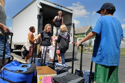 Kimberly Edwards of the West Central Community Center organizes the unloading of lunches for children in the West Central neighborhood at A.M. Cannon Park on Friday. (CHRISTOPHER ANDERSON / The Spokesman-Review)