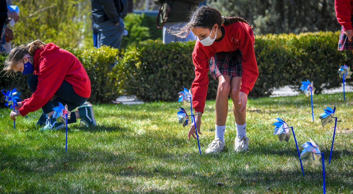 St. Aloysius Catholic School seventh-grader Makena Krauss, right, plants one of 100 pinwheels as part of the Pinwheels for Prevention Prayer Service for Child Abuse Prevention Month at the Diocesan Chancery on Wednesday at 525 E. Mission Ave.  (DAN PELLE/THE SPOKESMAN-REVIEW)