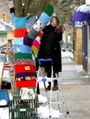 Corrine Bayraktaroglu adds another section of knitting to  the "Knit Knot Tree" on Xenia Ave. in Yellow Springs, Ohio on Wednesday, Feb. 27, 2008. The art project in this southwest Ohio village, already known for its artistic flavor and offbeat art, has become a conversation piece and even a photo op. (AP Photo/Skip Peterson) ORG XMIT: OHSP101 (Skip Peterson / The Spokesman-Review)