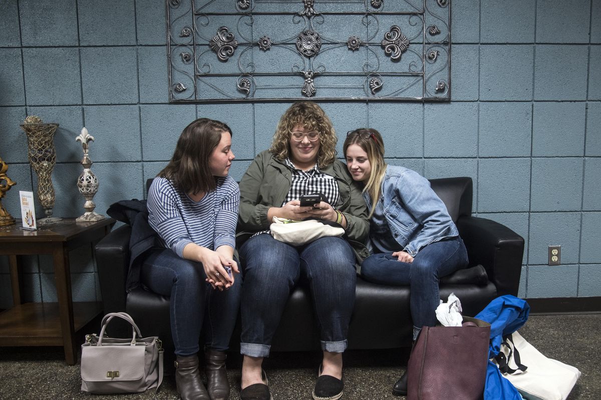 Moody Bible Institute students Melanie Baize, left, and Danielle DePace, right, visit with former student Miranda Smith on Thursday, Nov. 9, 2017, in the school’s lobby. Moody, based in Chicago, has announced it’s closing its branch campus in Spokane after 25 years. (Dan Pelle / The Spokesman-Review)