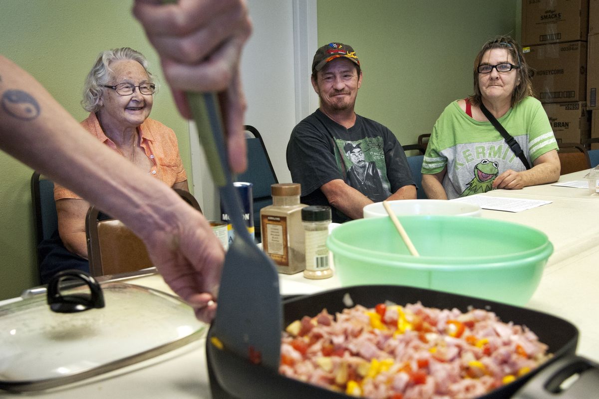 Our Place Community Ministries class coordinator Marjorie Lauersen, left, watches with Jerry Boatsman and Kathy Yunk as chef Martin Freatman prepares a quinoa and roasted vegetable dish Tuesday. (Dan Pelle)