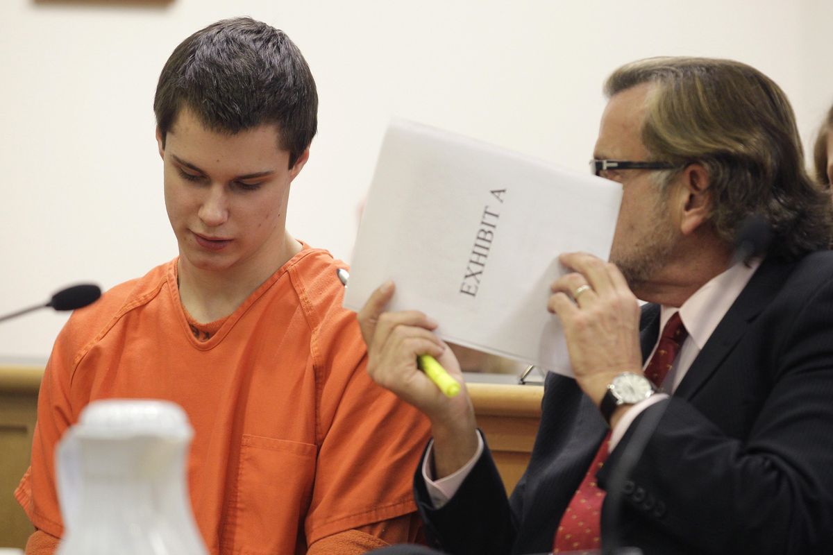 Attorney John Henry Browne uses a court document to shield his conversation with Colton Harris-Moore in Island County Superior Court on Friday in Coupeville, Wash. (Associated Press)