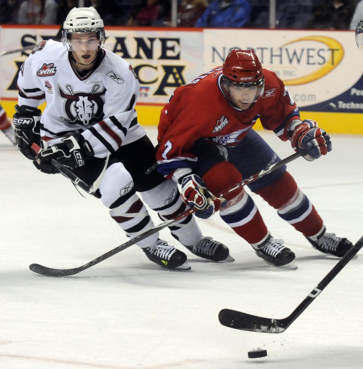 Red Deer’s Cody Gross, left, and Spokane’s Ryan Letts chase the puck during the first period.  (Dan Pelle / The Spokesman-Review)