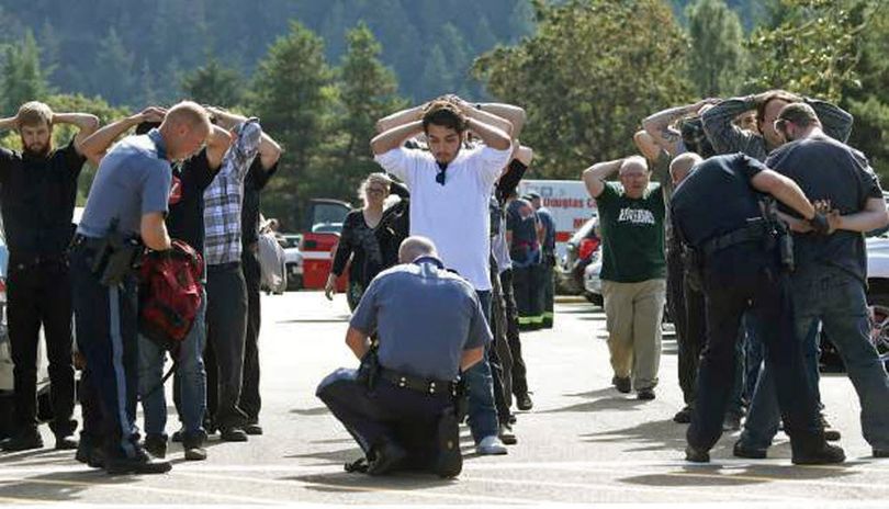 Police search students outside Umpqua Community College in Roseburg, Ore., Thursday, Oct. 1, 2015, following a deadly shooting at the college. (Mike Sullivan/Roseburg News-Review via AP)