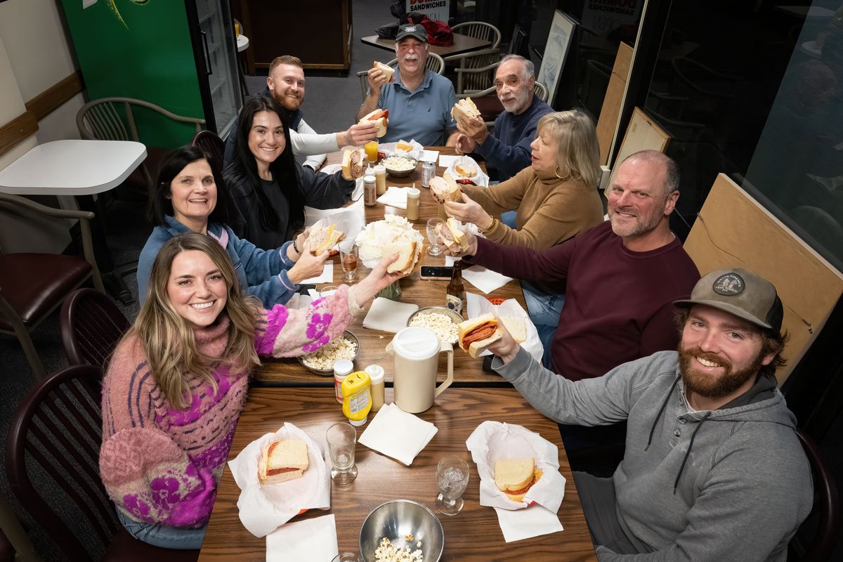 An end to an era, the Domini family holds up the last sandwiches in what they dubbed their “last supper” at Domini Sandwiches downtown after closing for the final time Thursday. Clockwise, from top, are Tom Domini, Joe Domini, Nancy Beatty, Nick Beatty, Keenan Batastini, Cara Ryan, Judy Domini, Tori Domini and Perry Domini.  (COLIN MULVANY/THE SPOKESMAN-REVIEW)