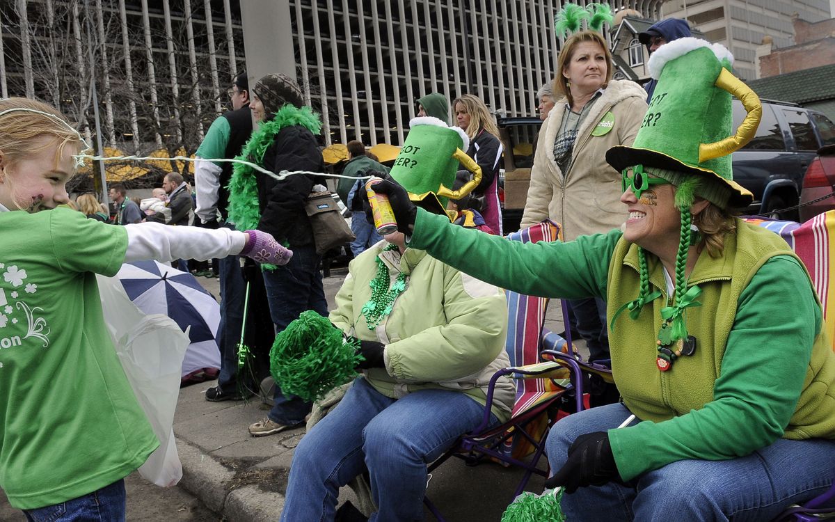Taylar LaRue,  9, gets a surprise blast of party string to the forehead from Pam Ellis, as Taylar and members of her Garco Construction St. Patrick’s Day Parade entry pass out candy near the corner of Main Avenue and Stevens Street in downtown Spokane on Saturday.  (Photos by DAN PELLE / The Spokesman-Review)