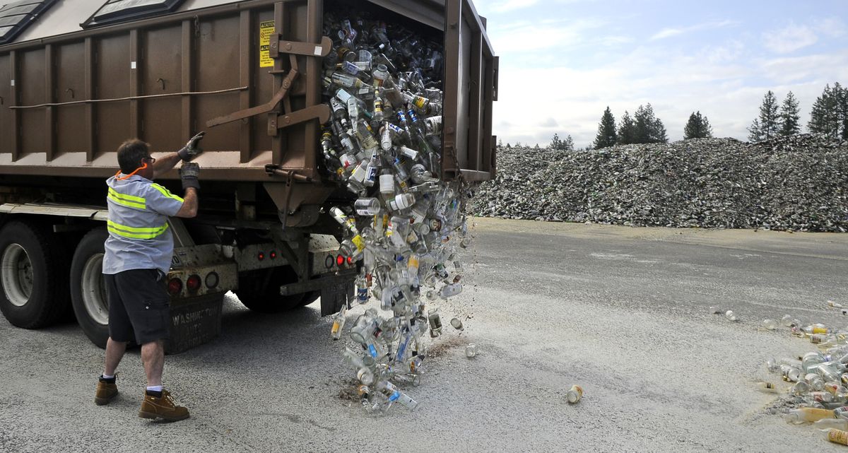 Chris Lacroix releases the gate on a recycling bin as clear glass crashes to the ground at a transfer station.