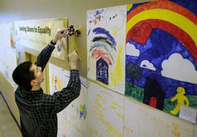
Kevin Brownlee, of Spokane's community development department, attaches  pinwheels Thursday next to children's handmade posters – on display at River Park Square – celebrating the 40th anniversary of the Fair Housing Act. 
 (. CHRISTOPHER ANDERSON / The Spokesman-Review)