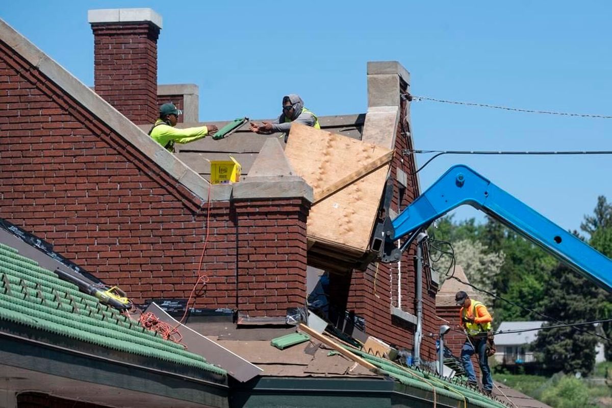Construction workers replace tiles Tuesday on the roof of the Pullman Depot Heritage Center.  (Zach Wilkinson/Moscow-Pullman Daily News)