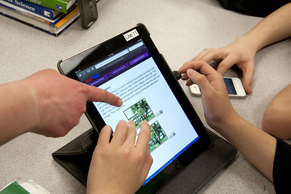 Libby Center eighth-grade students use an iPad to research a science project concerning the use of light.