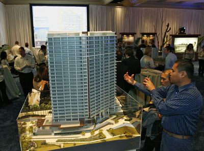 Prospective buyers look over a model of the proposed first phase of the Trump Ocean Resort Baja Mexico in San Diego in 2006.  (Associated Press / The Spokesman-Review)