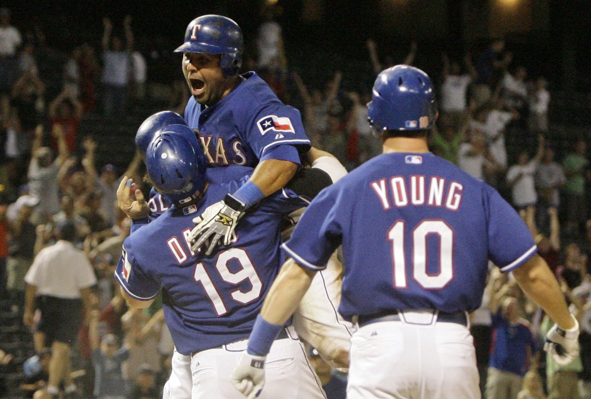 Texas’ Gerald Laird, center, takes to the air after scoring on Ramon Vazquez’s winning double in the ninth inning Tuesday.  (Associated Press / The Spokesman-Review)