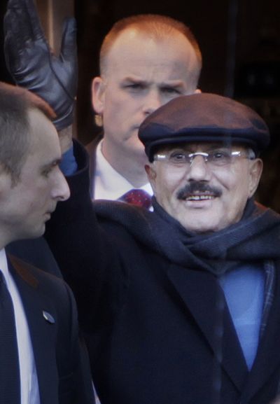 Yemeni President Ali Abdullah Saleh waves to protesters as he exits his hotel on Sunday. (Associated Press)
