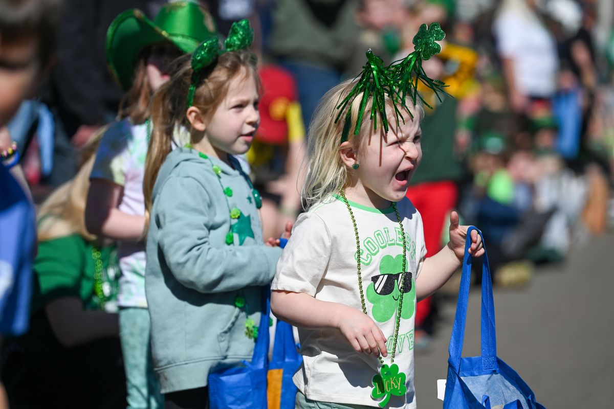 Five-year-old Paisley Campbell holds her candy bag and lets out a howl as large commercial trucks pass her viewing spot on Steven Street at the annual St. Patrick