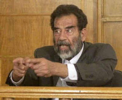 
In this image cleared by the U.S. military, former Iraqi President Saddam Hussein gestures in a courtroom at Camp Victory on the outskirts of Baghdad on Thursday.
 (Associated Press photos / The Spokesman-Review)