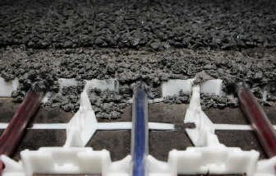 
**A model of a latticework of flexible plastic pipes, held in place by a plastic grid, covered by asphalt, which magnifies the sun's thermal power, is shown at Ooms Avenhorn Holding BV in Scharwoude, Netherlands. Associated Press
 (Associated Press / The Spokesman-Review)