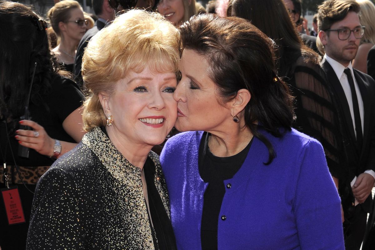 Carrie Fisher kisses her mother, Debbie Reynolds, on Sept. 10, 2011, as they arrive at the Primetime Creative Arts Emmy Awards in Los Angeles. (Chris Pizzello / Associated Press photos)