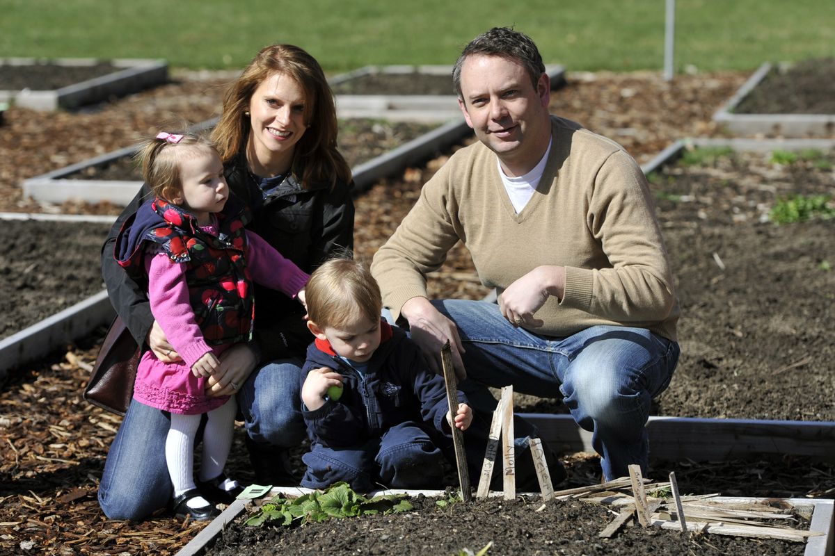 Mayor David Condon and his wife, Kristin, and their children, Hattie and Creighton, visit their garden spot at Grant Park on Saturday morning. (Dan Pelle)