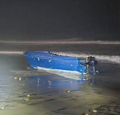 A vessel which capsized off the coast, prompting a search for its missing occupants, lies on a beach Saturday in Imperial Beach, Calif.  (U.S. Coast Guard)