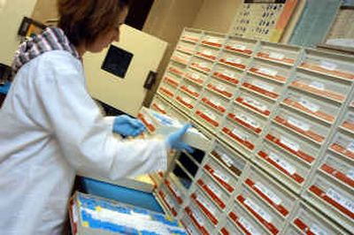 
Washington Animal Disease Diagnostic Laboratory technician Karissa Kelly files away blocks of animal tissue for later testing at Washington State University in Pullman. WSU's College of Veterinary Medicine is on the front lines of the war on terrorism, part of a nationwide early warning system to detect if bioterrorists have struck the United States.
 (Associated Press / The Spokesman-Review)