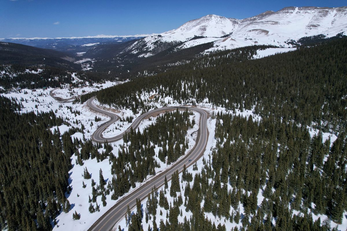 A road winds through the snow-covered Rocky Mountains at Hoosier Pass as seen from the air, Monday, April 18, 2022, near Blue River, Colo. Some drought-prone communities in the U.S. West are mapping snow by air to refine their water forecasts. It