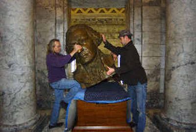 
Workers position a bronze bust of George Washington back in its old location on the third floor of the Legislative Building in Olympia. 
 (Associated Press / The Spokesman-Review)