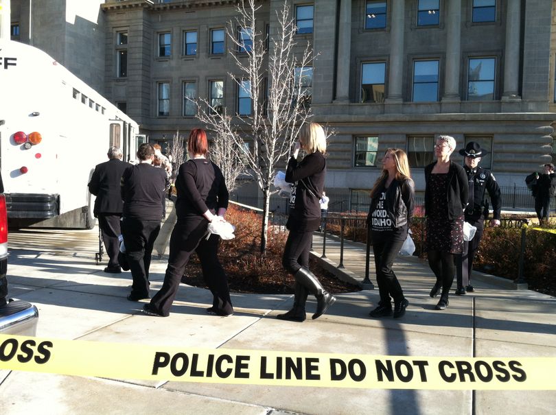 ISP officers lead arrested protesters out of the Capitol on Tuesday morning, to board a bus to jail (Betsy Russell)