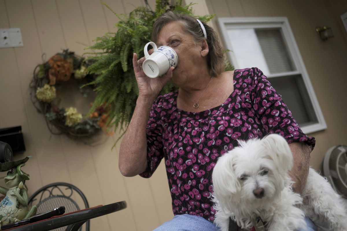 CORRECTS TYPE OF MENINGITIS TO FUNGAL INSTEAD OF BACTERIAL - Patsy Bivins, 68 of Sturgis, Ky., drinks coffee while sitting on her porch with her dog Little Britches at her apartment in Sturgis, Ky., Friday, October 5, 2012. Bivins was injected with steroids at St. Mary Sugricare in Evansville, Ind., who notified her of possibly being infected with fungal Meningitis. (Stephen Dennee / Fr170568 Ap)