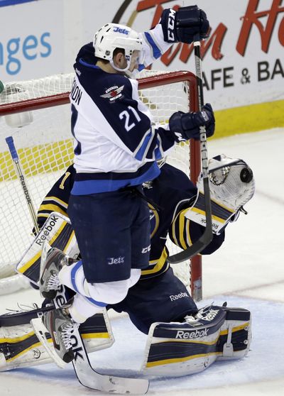 Buffalo Sabres goalie Jhonas Enroth makes a save in front of Winnipeg Jets' Aaron Gagnon during third-period action. (Associated Press)
