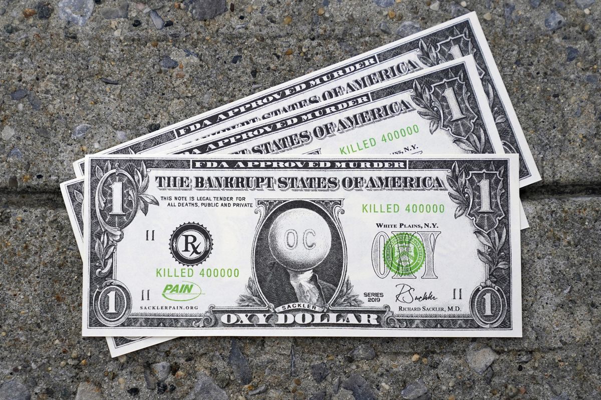 Fake money with messages about Purdue Pharma are thrown on the ground during a protest outside the courthouse where the bankruptcy of the company is taking place in White Plains, N.Y., Monday, Aug. 9, 2021. Purdue Pharma's quest to settle thousands of lawsuits over the toll of OxyContin is entering its final phase with the grudging acceptance of most of those with claims against the company.  (Seth Wenig)