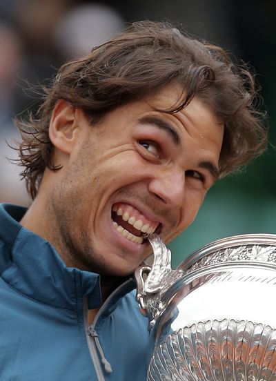 Rafael Nadal bites the cup after defeating David Ferrer in the men's French Open final. (Associated Press)