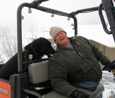 Craig Thomas with his dog plowing his neighbor’s driveway. (File)