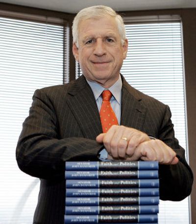 
Former U.S. Sen. John Danforth leans on a stack of his latest book 