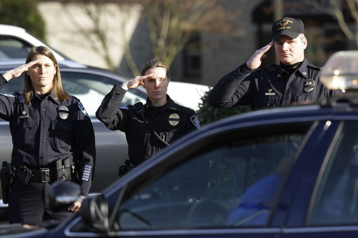 Police officers salute as the bodies of four slain Lakewood Police officers arrive in a procession at the Mountain View Funeral Home, Tuesday, Dec. 1, 2009, in Lakewood, Wash. The four Lakewood Police officers were killed Sunday, Nov. 29, 2009 as they sat in a coffee shop in Parkland, Wash. (Ted Warren / Associated Press)